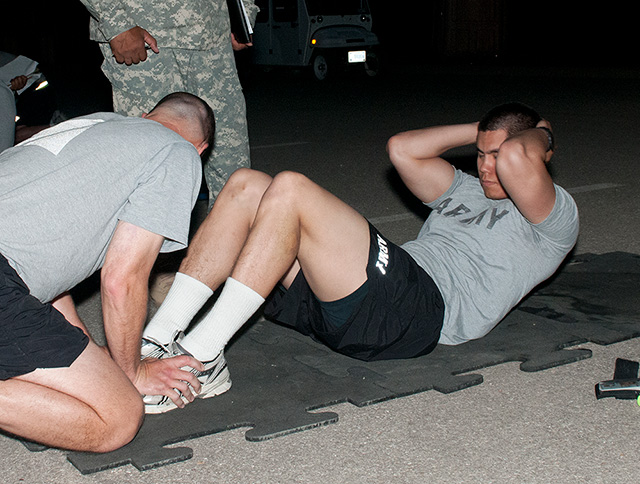 Army recruits doing the sit up assessment


